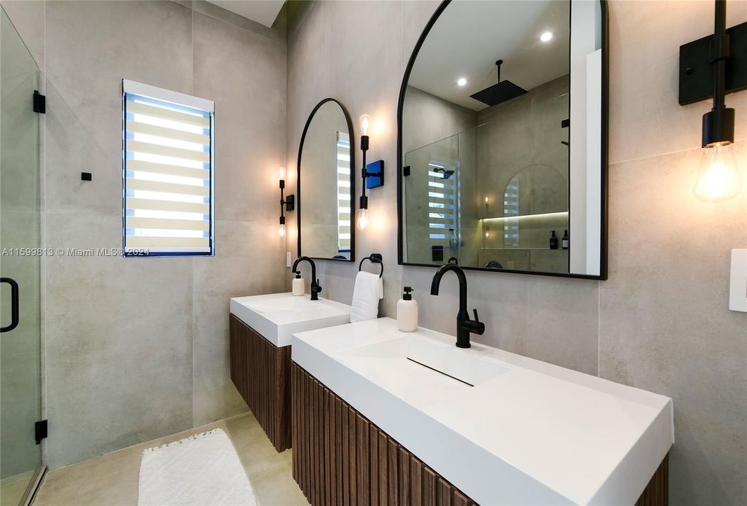 Primary Bathroom: Indulge in the elegance of this modern bathroom, complete with dual sinks and chic black fixtures. The large mirrors and ample lighting make mornings a delight.