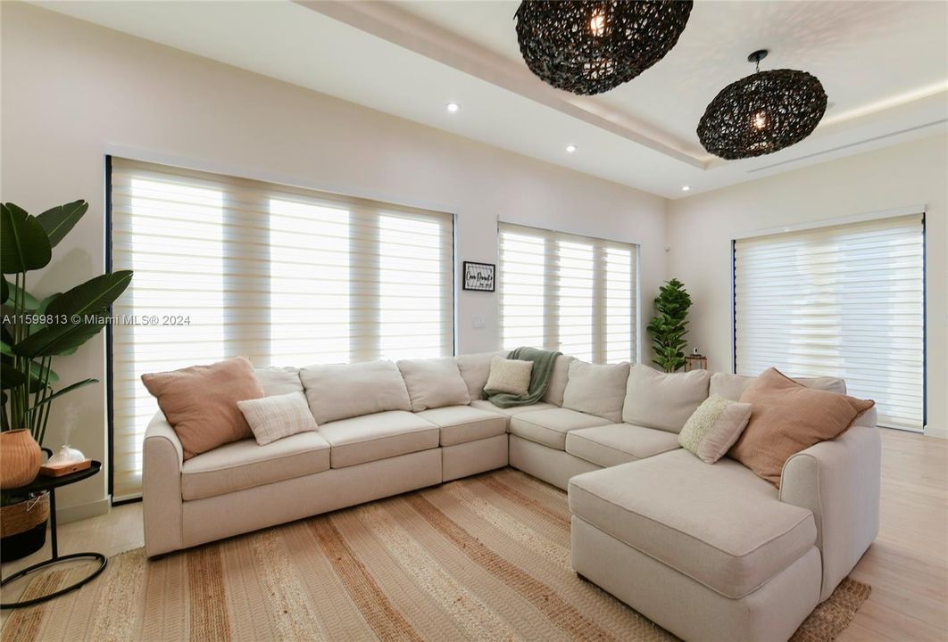 This bright and airy living room offers a comfortable sectional and chic decor, making it an ideal space for unwinding or entertaining guests.