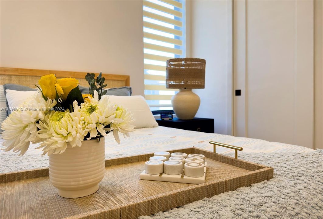 Bedroom Detail: A close-up of the bedroom showcases thoughtful details like a cozy vase of flowers and soft bedding, creating a welcoming and serene environment.