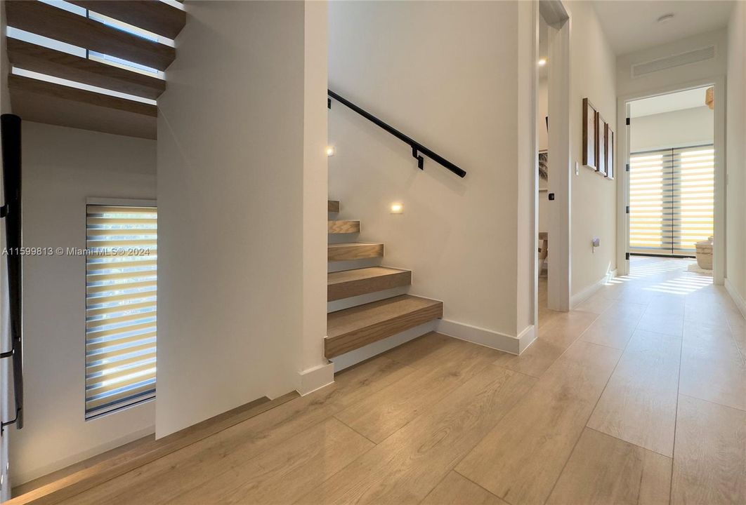 Staircase: A beautifully designed staircase with soft lighting guides you through the home. The natural wood steps and sleek railing add a touch of modern elegance.