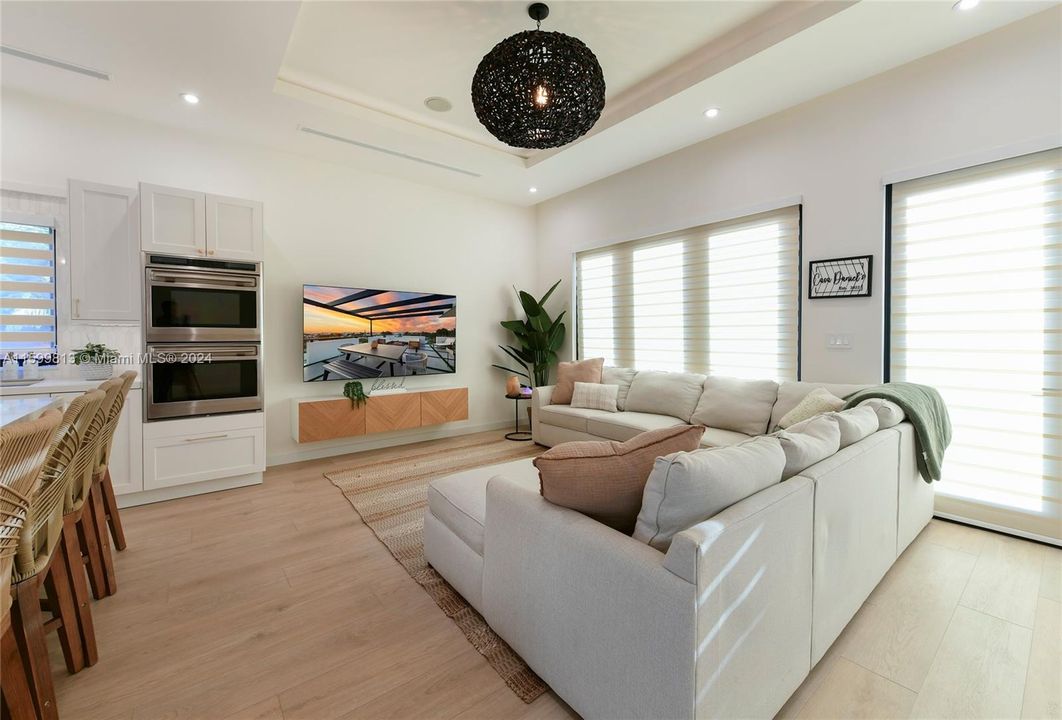 Living Area with TV: Gather around for movie nights or enjoy the view from this spacious living area. The modern entertainment setup and open layout create a welcoming atmosphere.