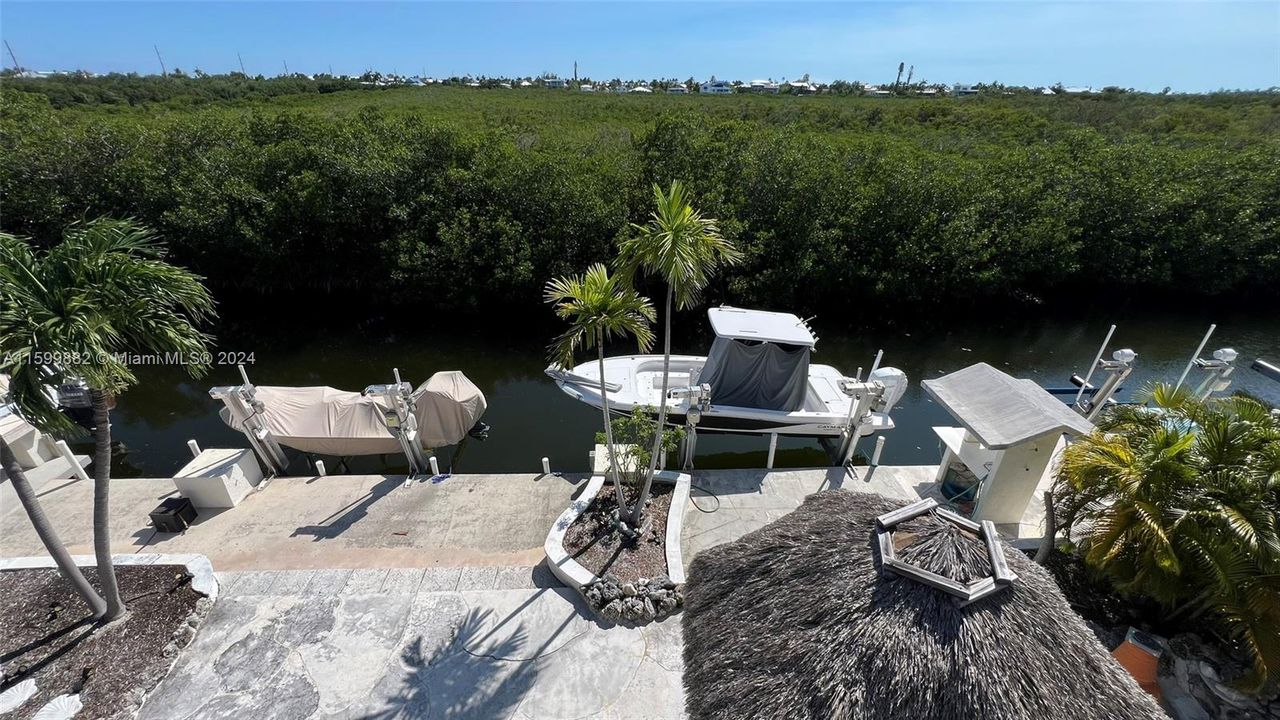 Nestled amid lush palms, this charming two-story home features a unique architectural design with a spacious two-car garage and a welcoming front porch. Perfect for enjoying the sunny Florida Keys lifestyle.