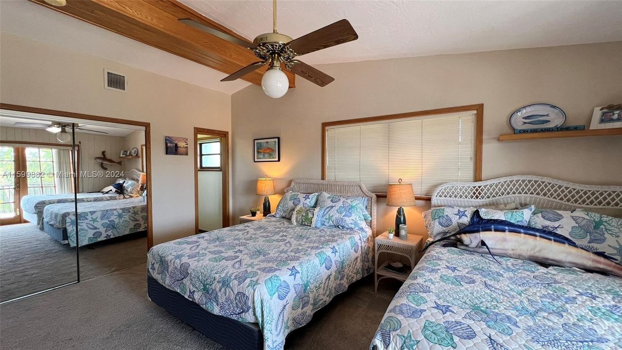 Guest bedroom, complete with cozy carpeting, a comfortable bed, and a dedicated workspace. Ideal for guests or a home office setup, this room exudes warmth and charm.