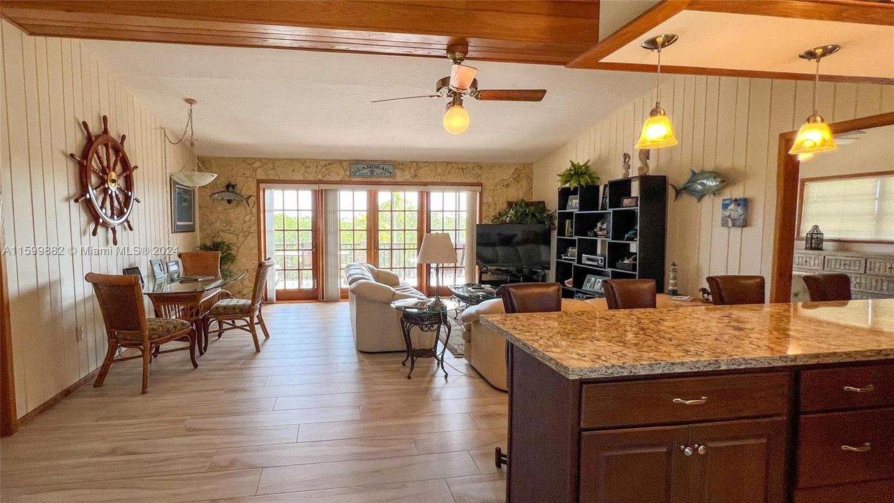 Step into a cozy living space adorned with nautical accents and abundant natural light from the French doors. The open layout seamlessly connects to the dining area, creating an ideal setting for entertaining guests.