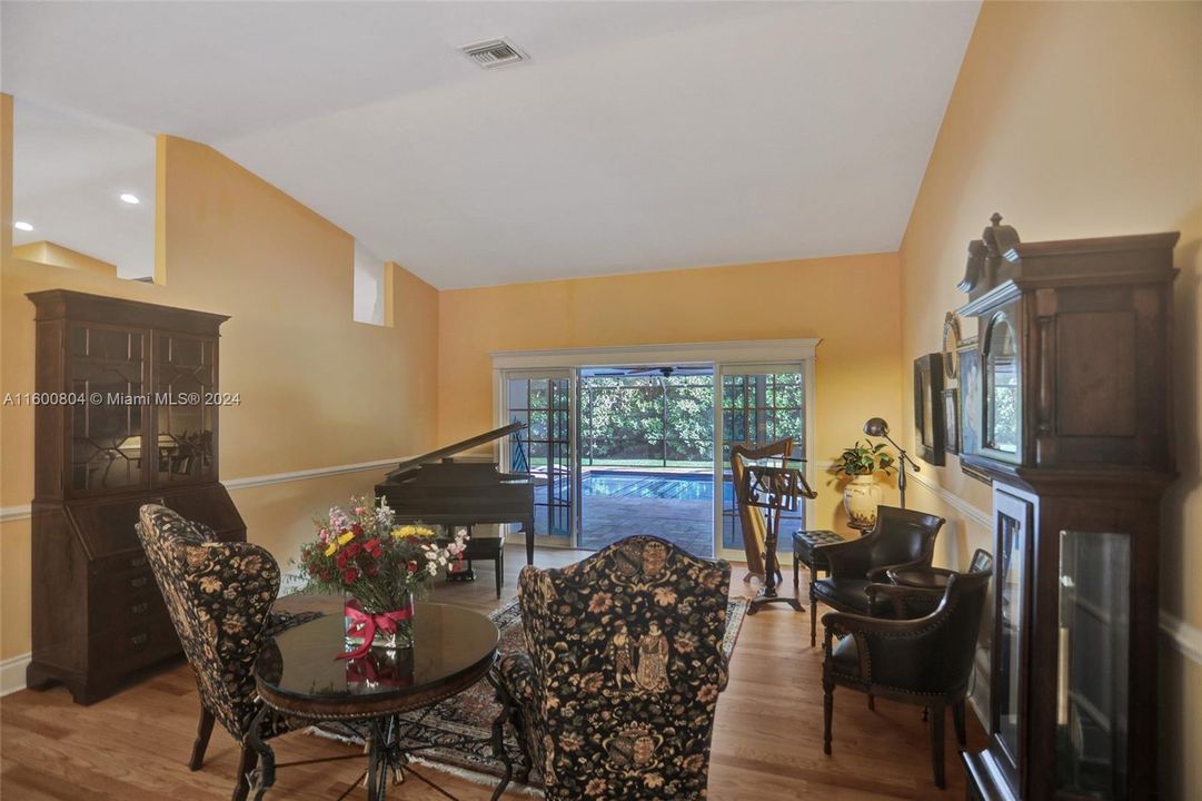 Living/music room with open French doors to deck and pool