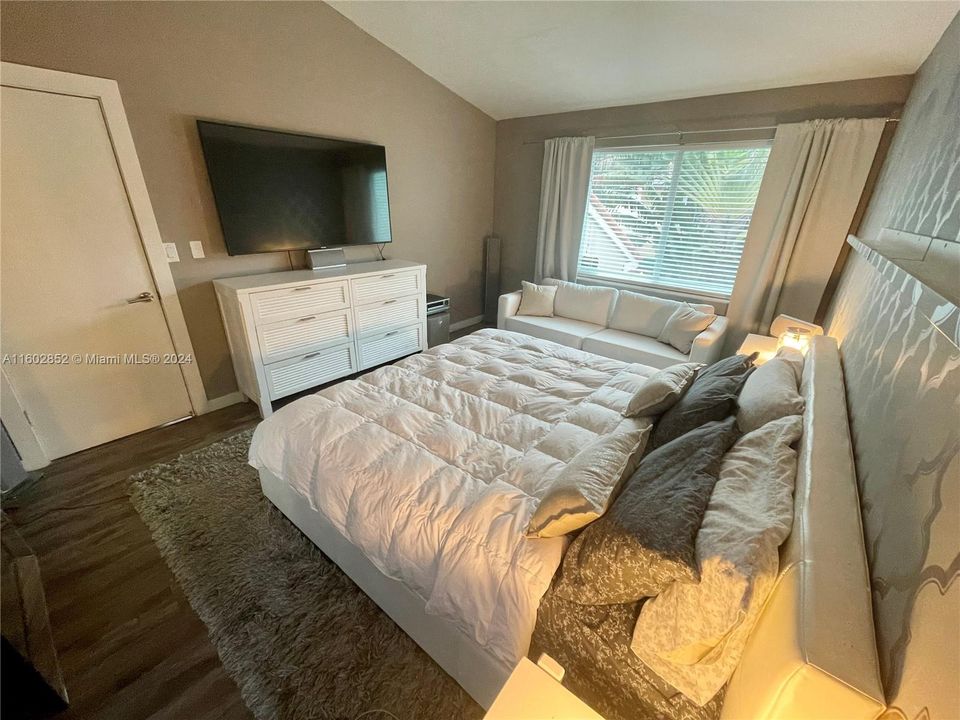 Master Bedroom with valved ceiling and elegant wallpaper.