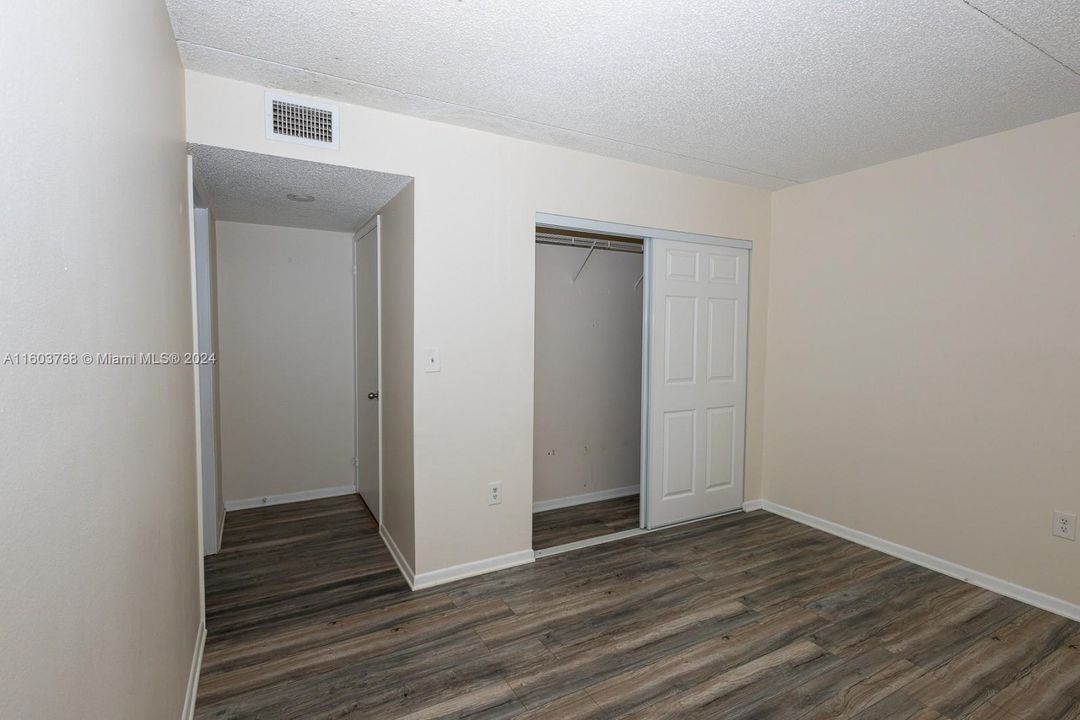 Primary bedroom with closet (to the right) and entrance to en-suite bath (to the left).