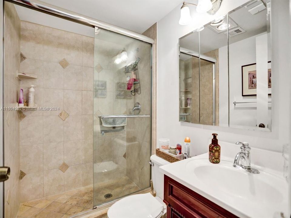 Guest Bath a with a Stall Shower and marble counter top on the wood cabinetry!