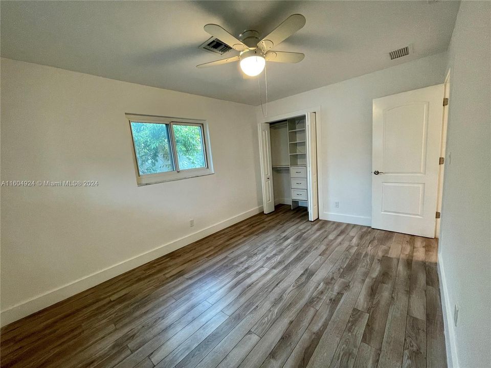 Spacious second bedroom with ceiling fan and wall closet.