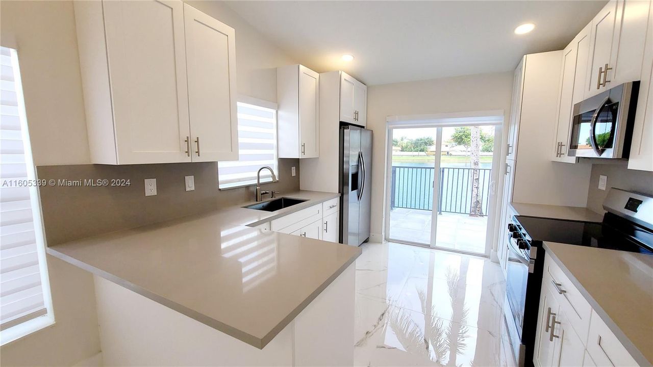 Custom white cabinetry, granite counters and stainless steel appliances