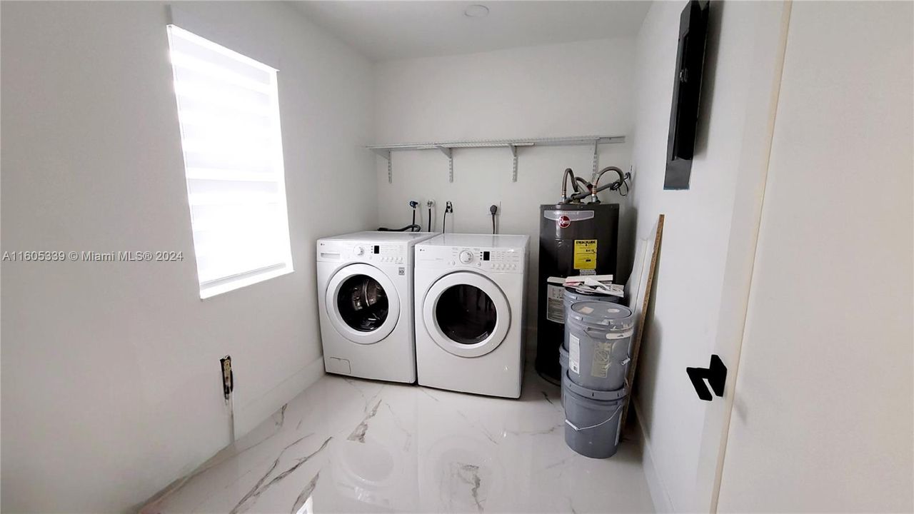 Huge laundry room featuring new washer, dryer, and water heater