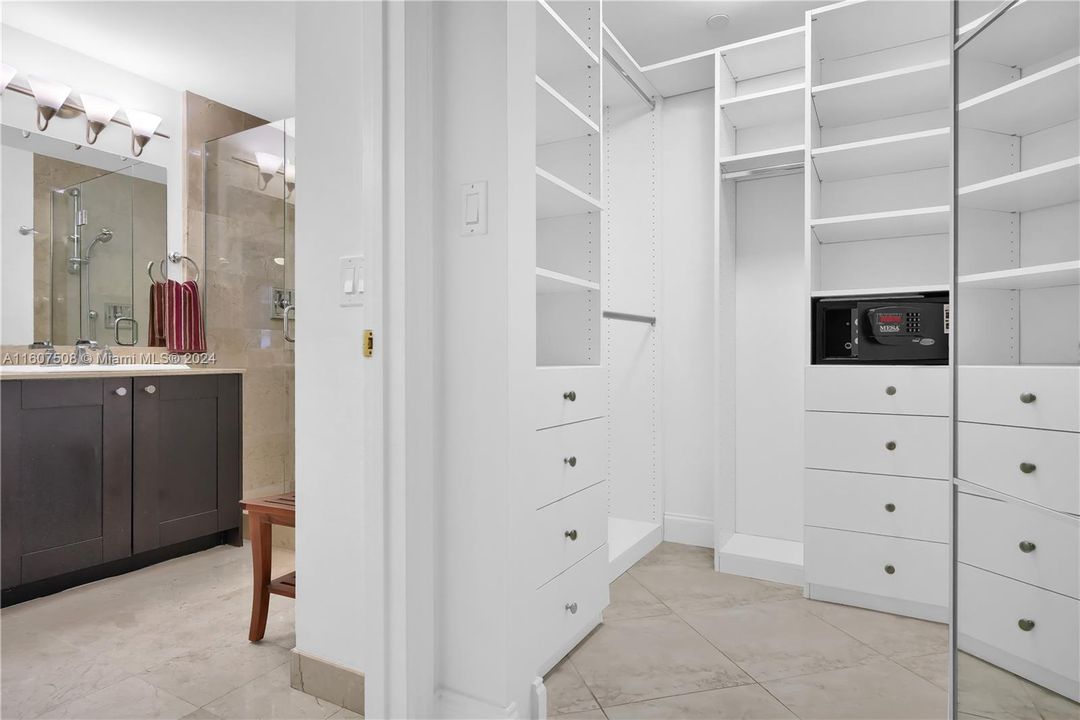 Walk-in closet in Primary Bedroom with mirrored folding doors.