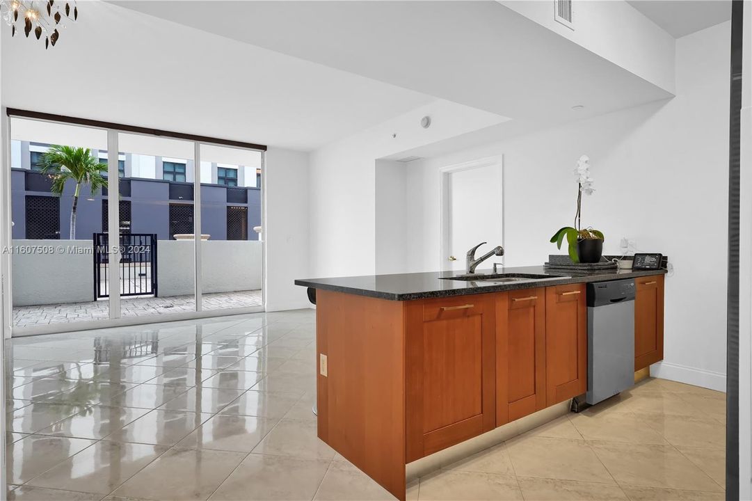 Open plan with kitchen island, living room and patio.