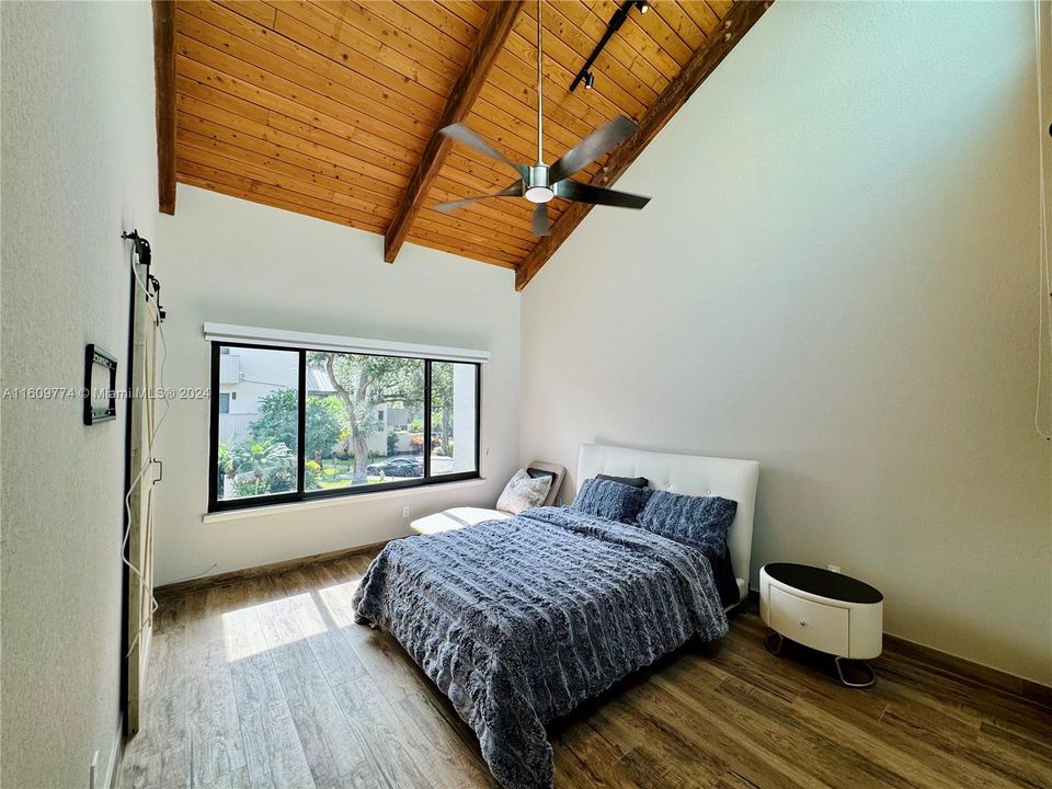 Secondary bedroom with vaulted ceiling and large windows, similar to Main bedroom