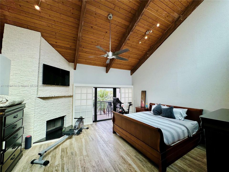 Main Bedroom with large, bright windows, fireplace, balcony