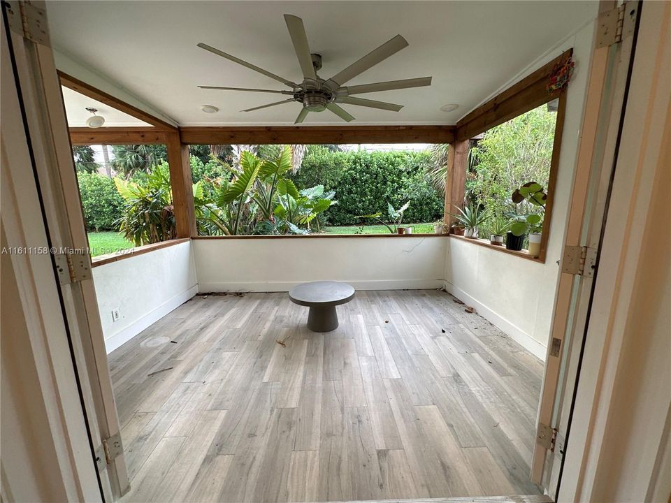 open air porch overlooks large fenced in yard with fruit trees