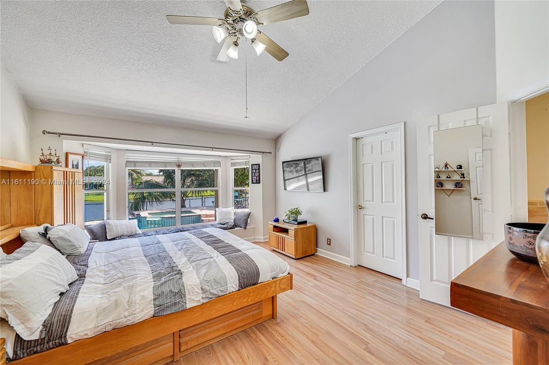 Spacious master bedroom with pool and lake views.