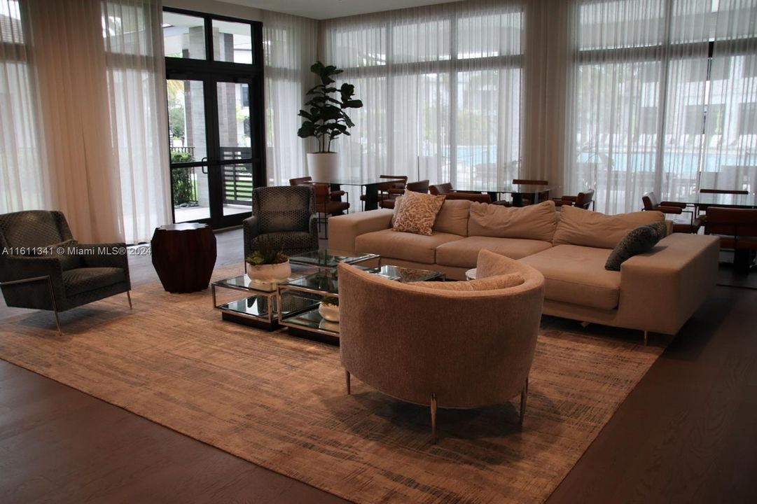 CLUBHOUSE LOBBY WITH POOL IN THE BACKGROUND