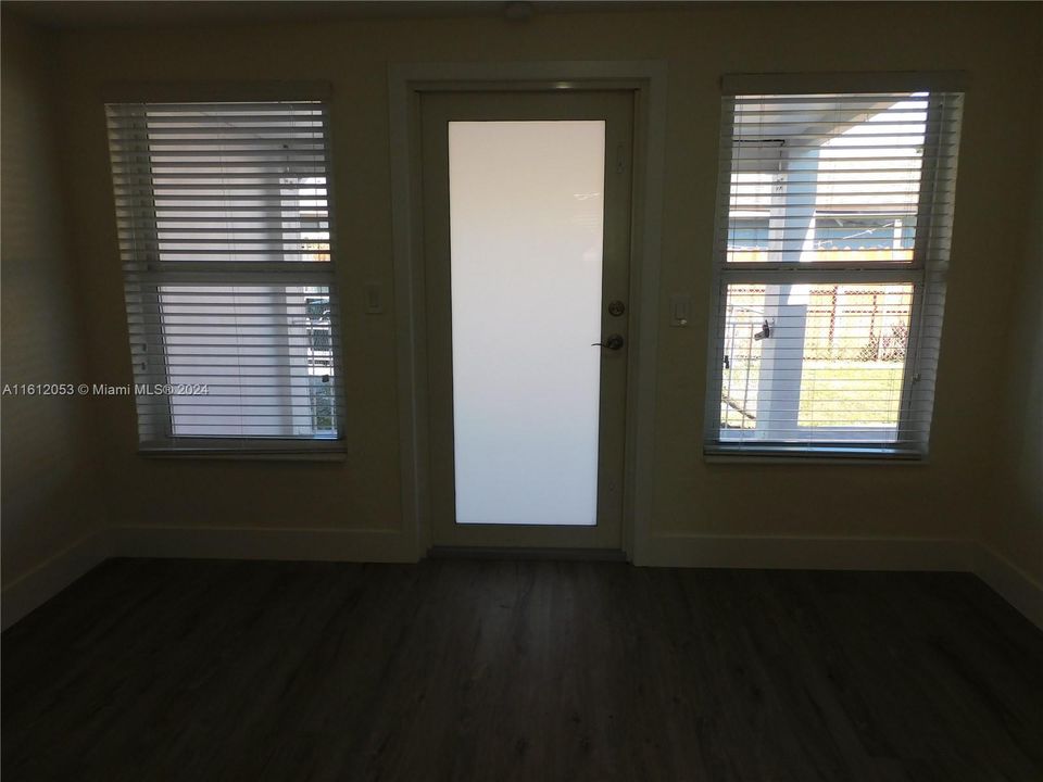 Living room view to front entrance - nice blinds throughout.