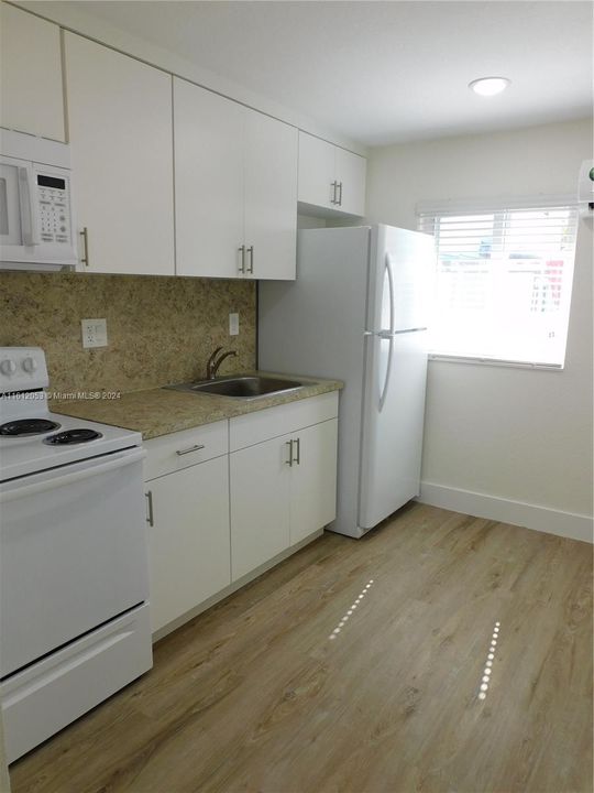 Fully equipped kitchen with plenty of cabinetry 0 maximizing space and utility.