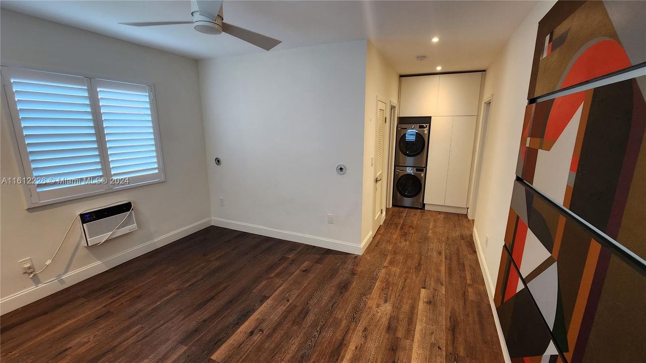 Spacious Bedroom with modern adjustable lighting, new wall A/C unit, new impact windows and fan.