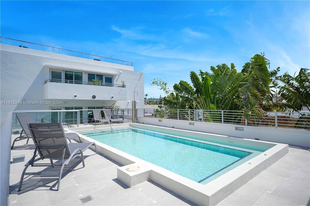 Sunlit pool area with ample lounge space, offering full sunlight exposure. Enjoy a relaxing swim.