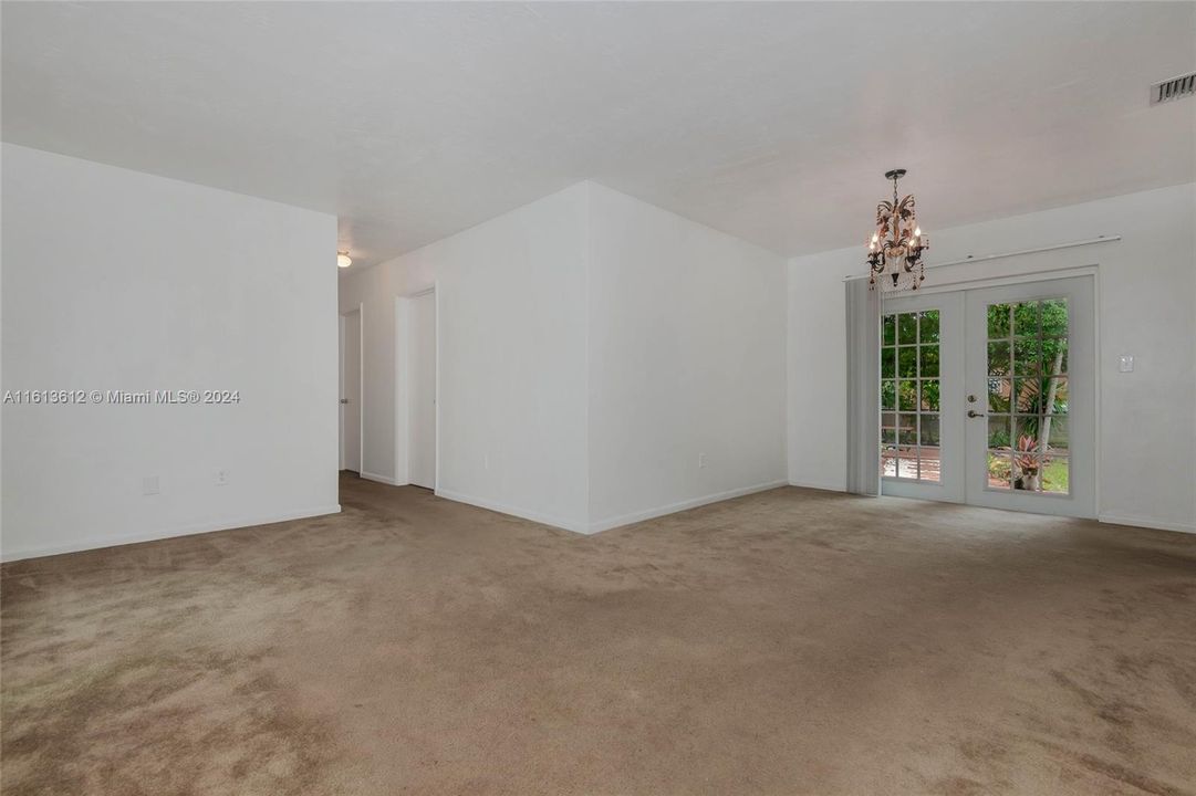 From the front door to the living room and the dining area off the kitchen with a chandelier and French doors to the rear yard.