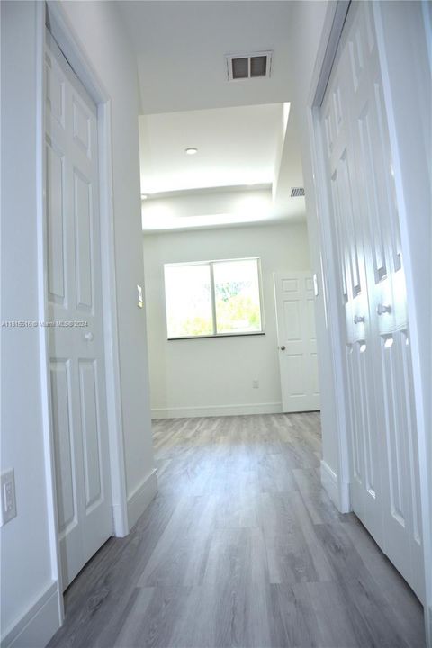 Hallway featuring His & Hers Walking Closets.