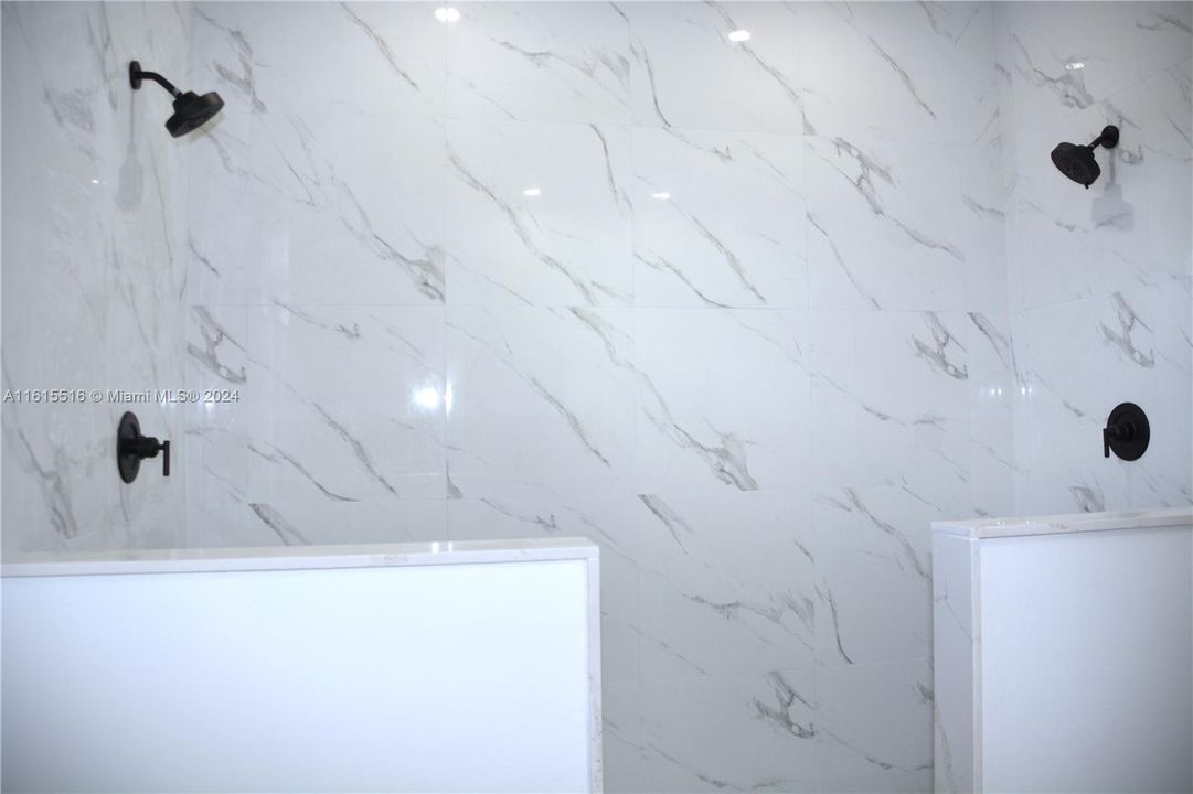 Bathroom featuring His & Hers tile showers.