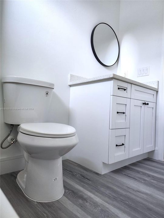 Visit Bathroom with hardwood / wood-style floors and toilet