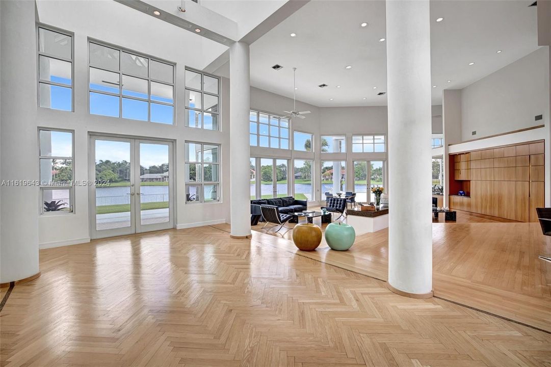 As you step inside, you'll be captivated by the over 20 foot high ceilings, architectural lighting and ceiling, custom wood built-ins, and sleek columns flanking the striking foyer skylight that defines the interior, along with real hardwood flooring.