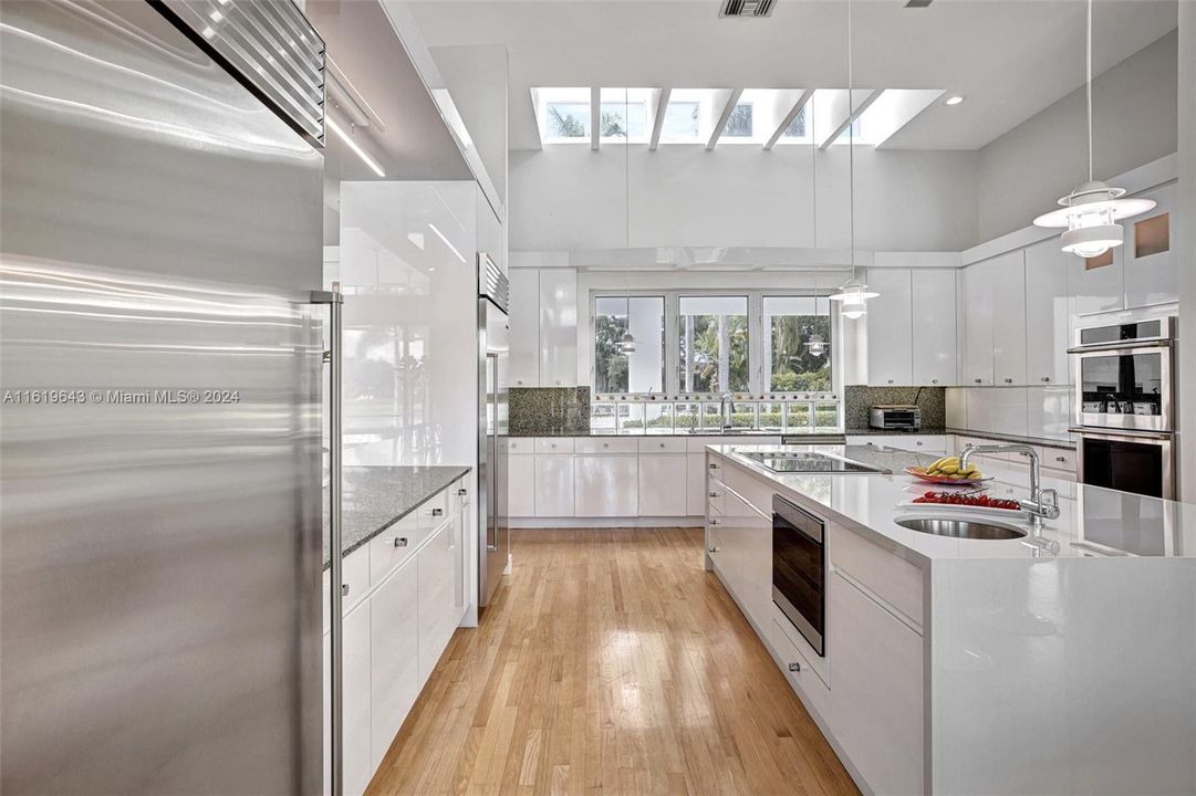 The recently renovated kitchen, featuring top-of-the-line appliances, a white waterfall quartz island, and Sub-Zero refrigeration, is a chef’s dream.