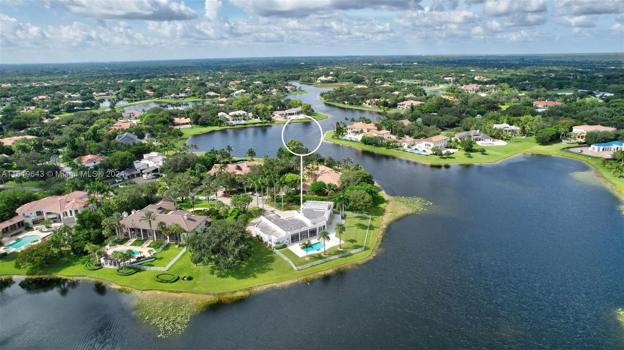 Situated on a point lot with 430 feet of waterfront, it boasts sweeping panoramic views in the coveted Windmill Ranch Estates, designed by award-winning Rex Nichols.