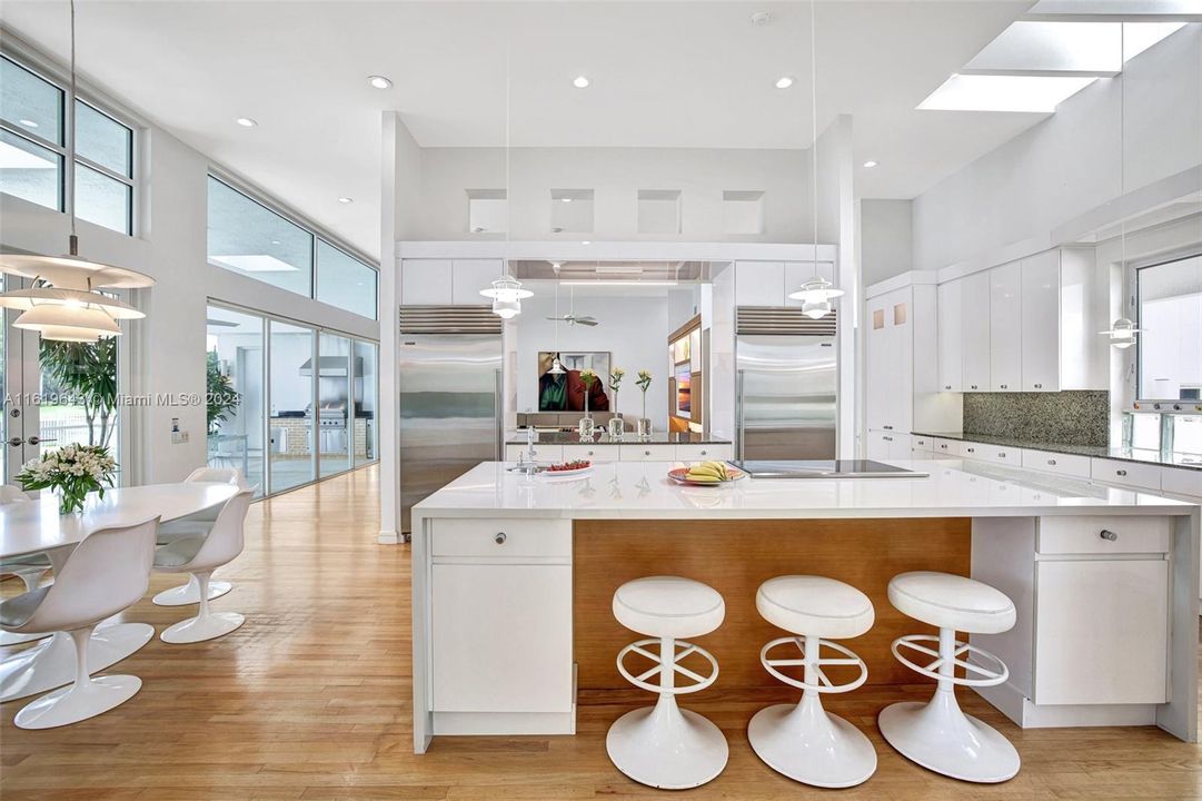 The recently renovated kitchen, featuring top-of-the-line appliances, a white waterfall quartz island, and Sub-Zero refrigeration, is a chef’s dream.