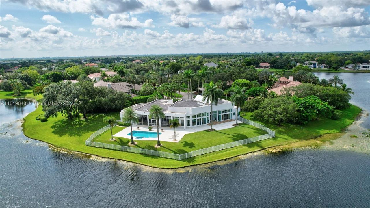 Situated on a point lot with 430 feet of waterfront, it boasts sweeping panoramic views in the coveted Windmill Ranch Estates, designed by award-winning Rex Nichols.