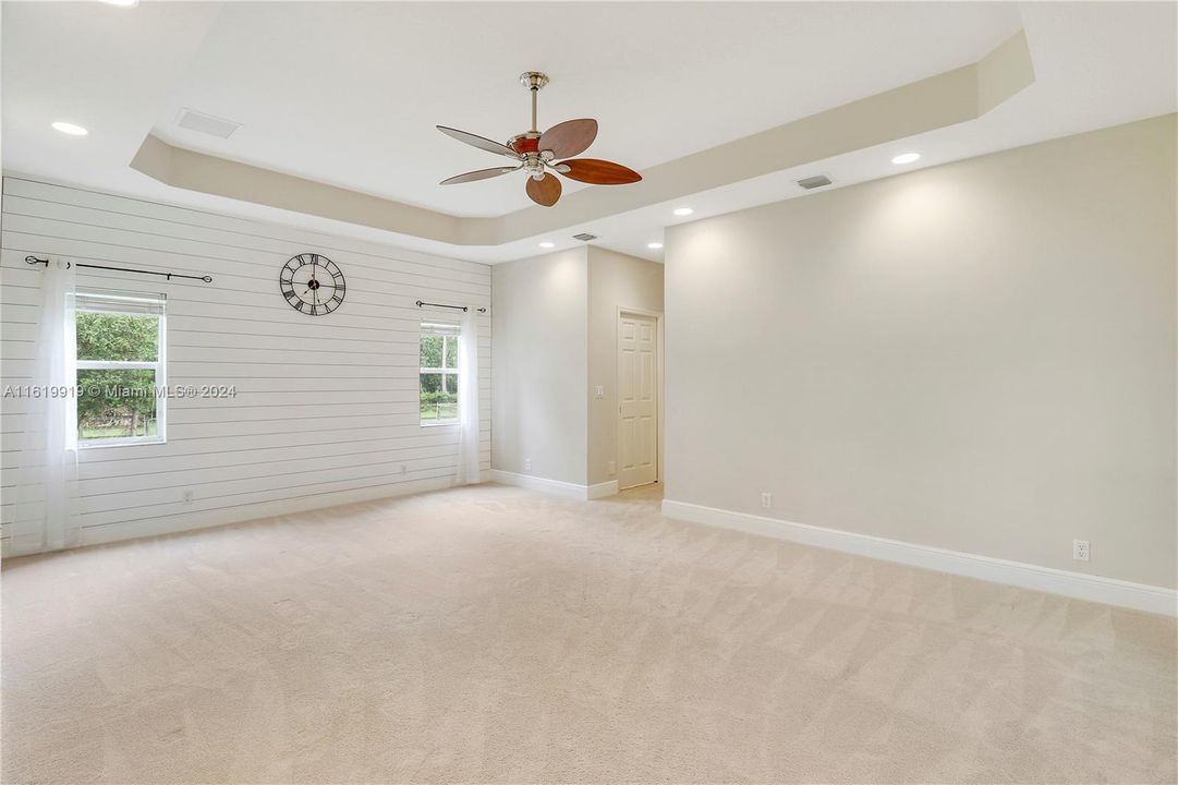 Master bedroom is light and bright with coffered ceiling and recessed lighting