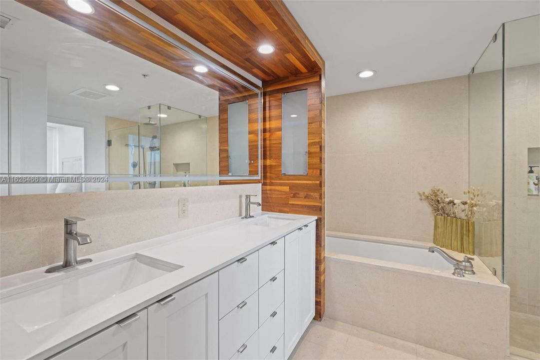 Primary bathroom with separate shower, tub, and dual vanities