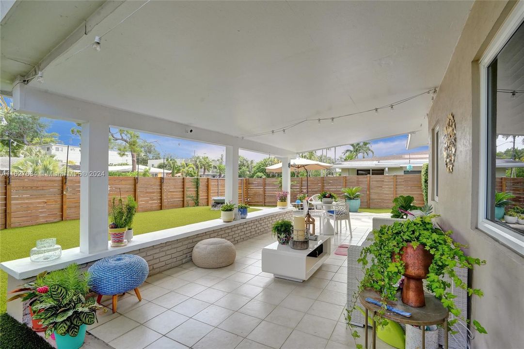 Front of house, with enclosed yard and artificial turf.