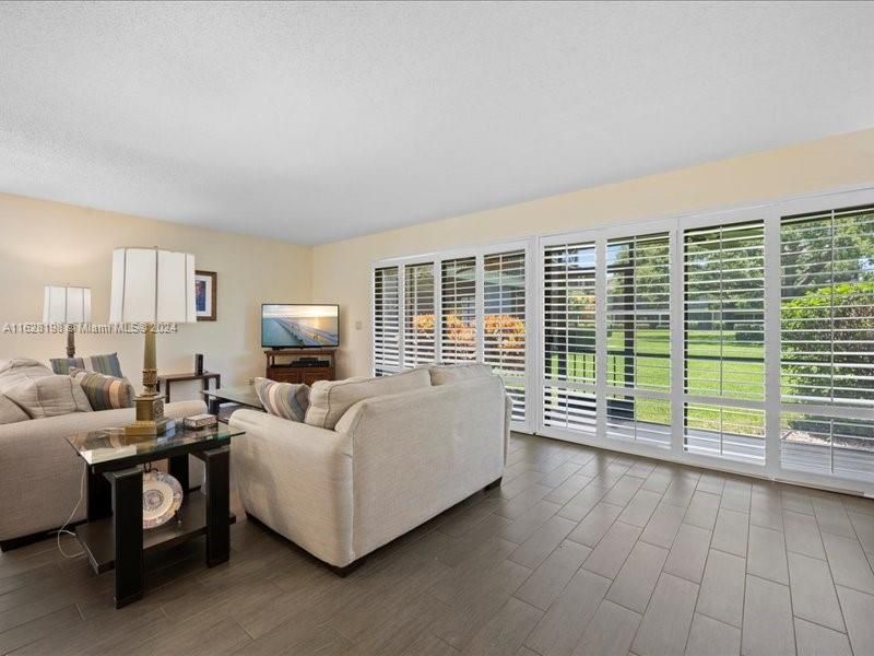 Southern exposure ,nice breezes.  Double sliders with custom Plantation Shutters , Wood -like tile flooring in the Living /Dining area  . Huge screen porch 20x6