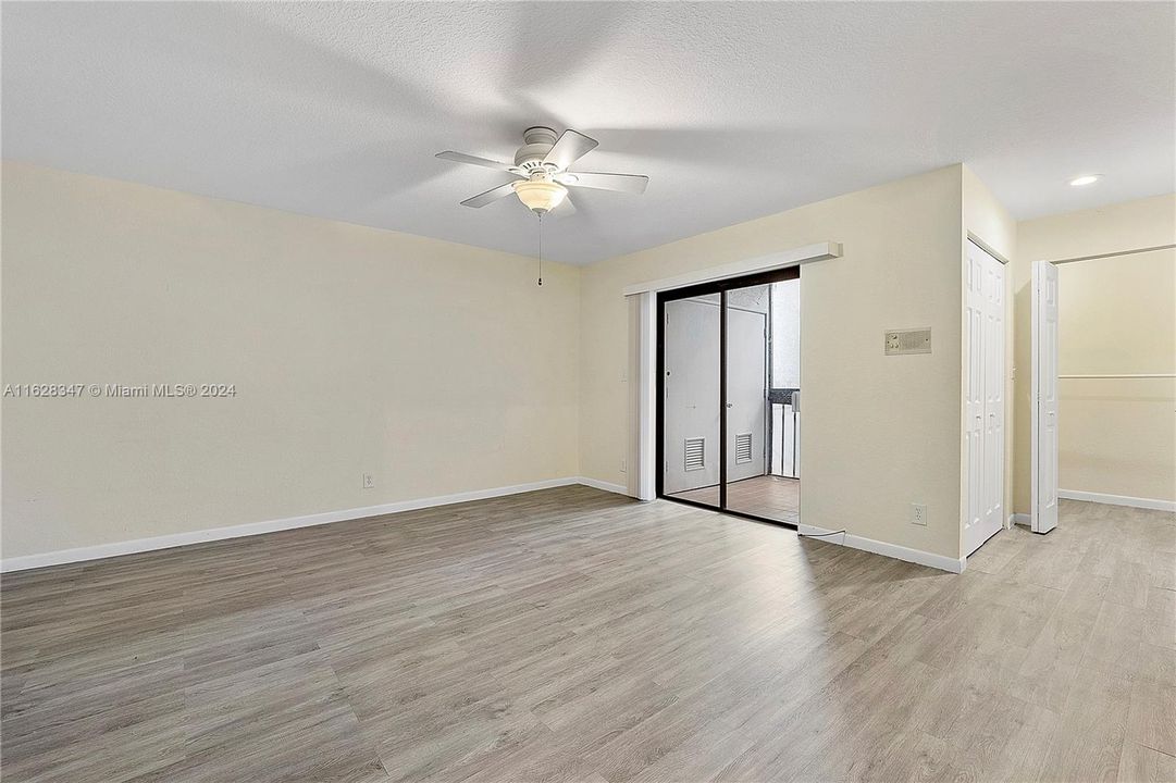 Primary Bedroom and screened balcony. Washer & Dryer behind closed doors on the balcony.