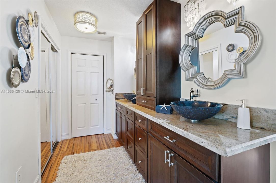 Double sinks custom vanities w/ gorgeous glass vessel sinks.