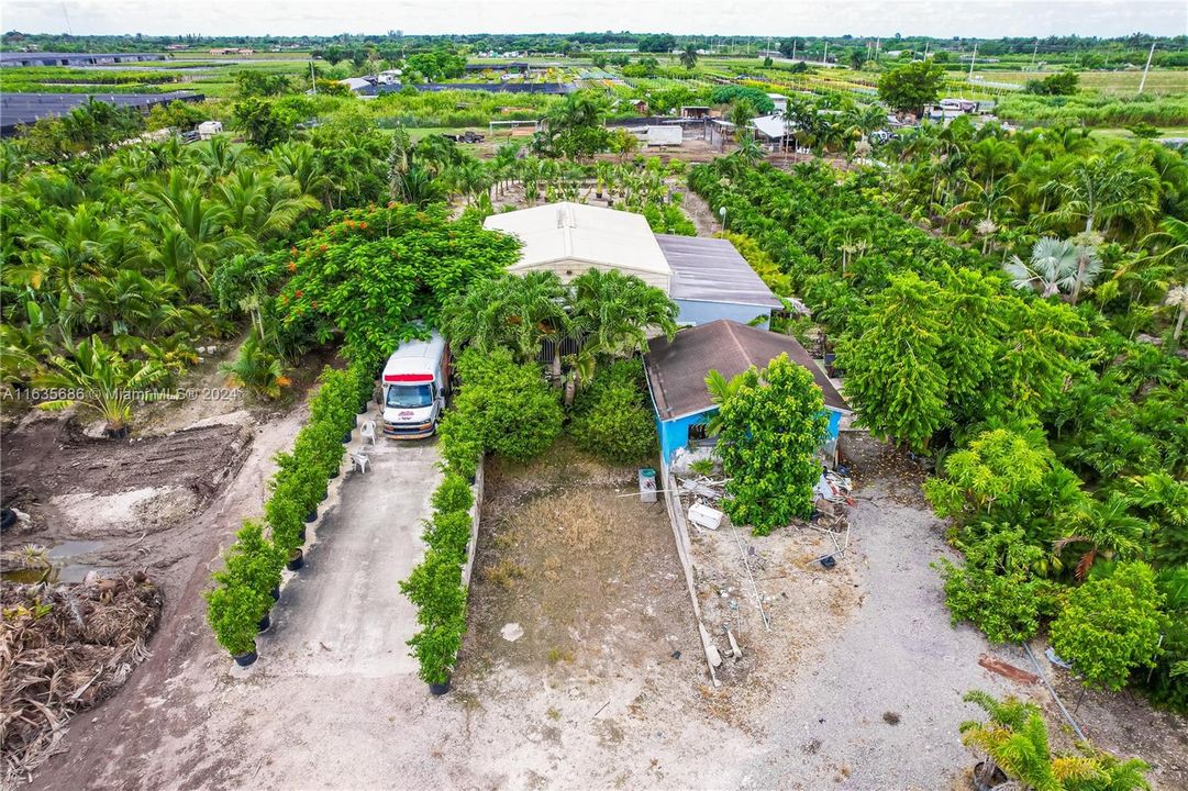 LOADING DOCK W/ MANAGERS APT  APARTMENT & A DETACHED OFFICE (THIS 5 ACRE FOLIO CAN BE SOLD SEPERATELY.) THE LOADING DOCK IN CENTER IS DECK HEIGHT THE MANAGER PLANTED T4RES SELLER WILL REMOVE . TH ORIGINAL OFFICE BLDG(BLUE) CAN BE REVAMPED