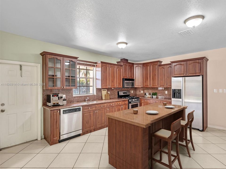 Ample kitchen, with granite counters, gas range, and large pantry. Virtually Staged Photo.