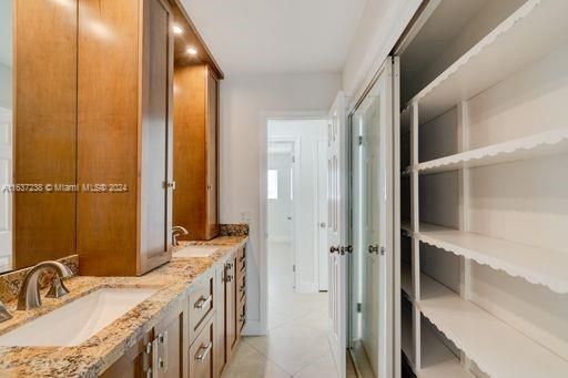 Updated modern 2nd bathroom with custom wood cabinetry & closet for plenty of storage,  large mirrors, bathtub and direct access to terrace, pool, patio.