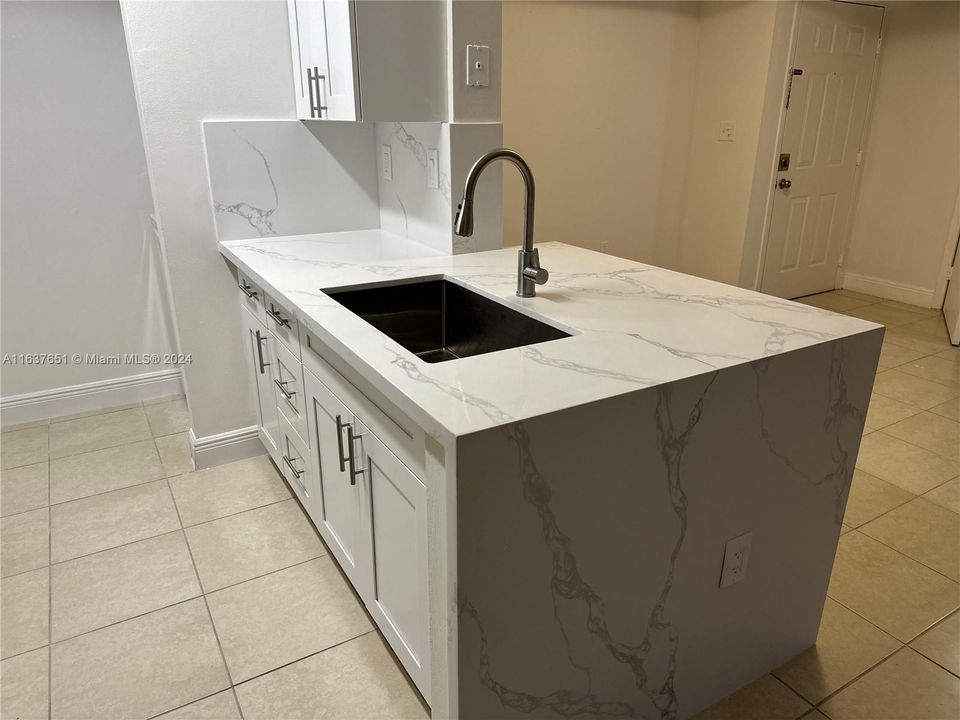 Brand new kitchen - marble counter tops with a waterfall finish, cabinets, & stainless steel appliances.