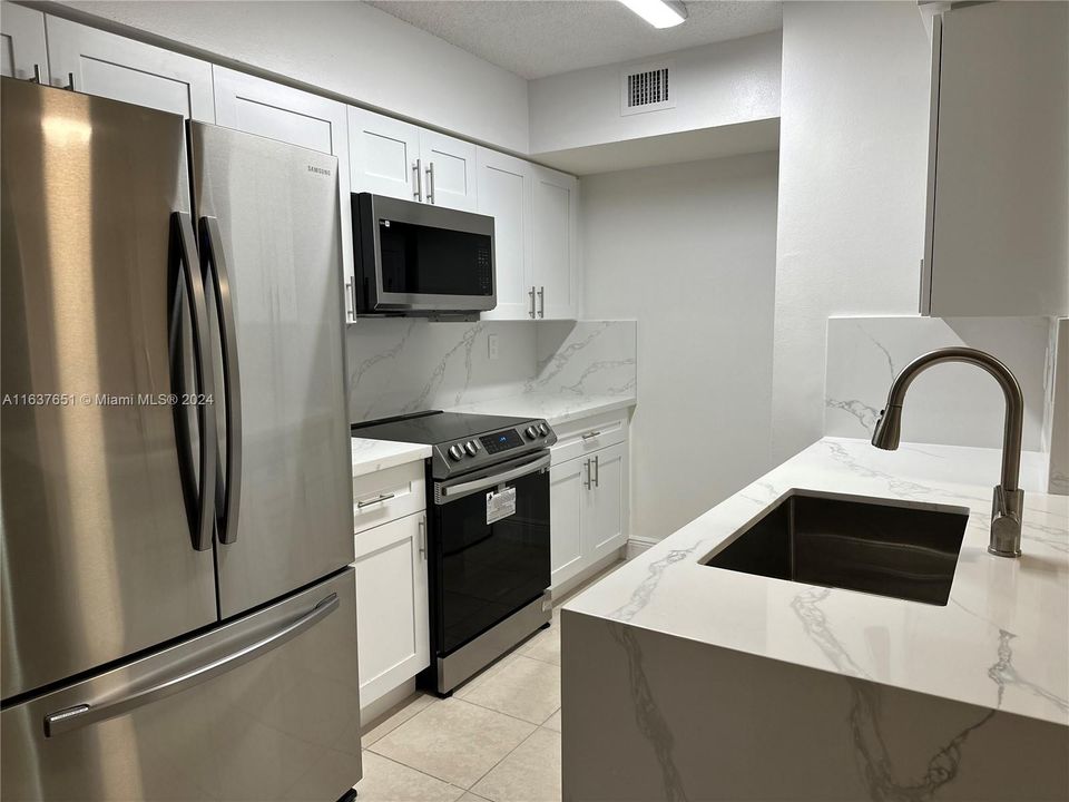 Brand new kitchen - marble counter tops with a waterfall finish, cabinets, & stainless steel appliances.