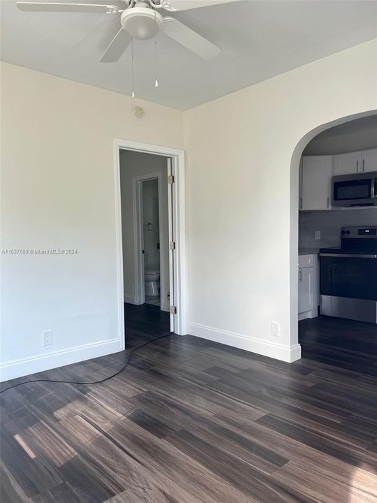 Main living area of 1 bedroom house facing bedroom and kitchen entrances