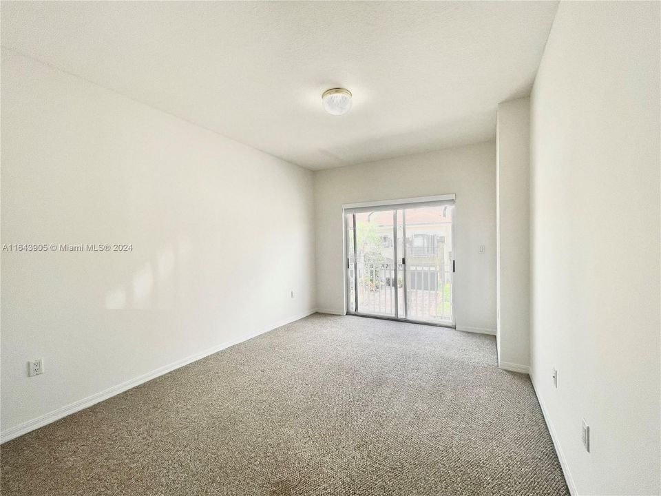 2nd bedroom with private balcony overlooking the community.