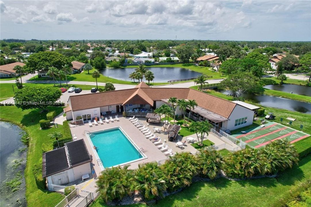 VIEW OF COMMUNITY POOL WITH RECREATION ROOM TO LEFT SURROUNDED BY PONDS