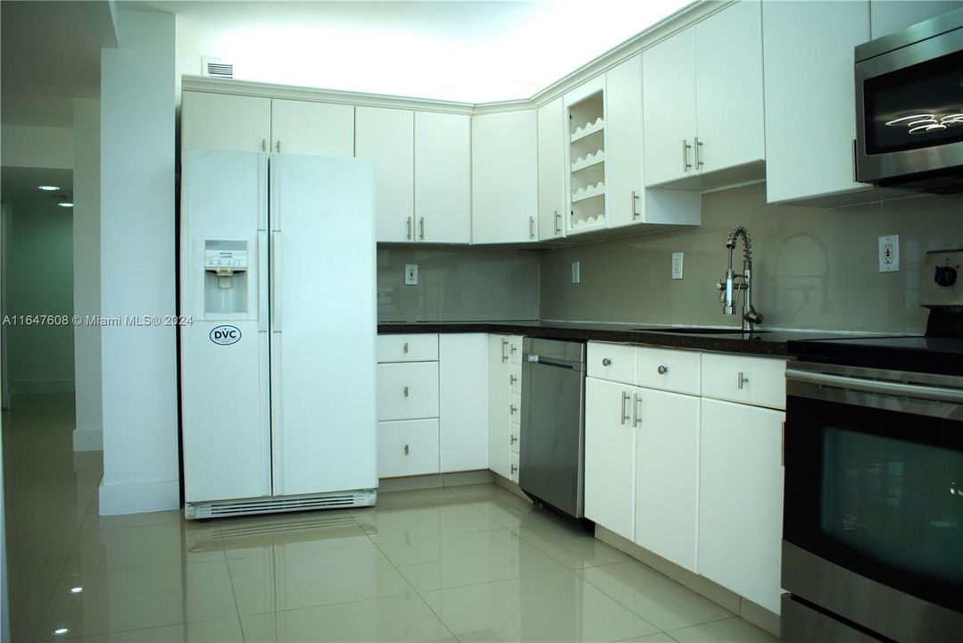 Modern open concept kitchen with stainless steel appliances.